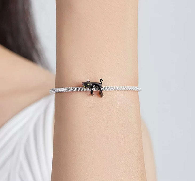 Verspielte schwarze Katze als Charm – baumelnd am Armband, humorvoll & liebevoll gestaltet, ideal für Katzenfans.