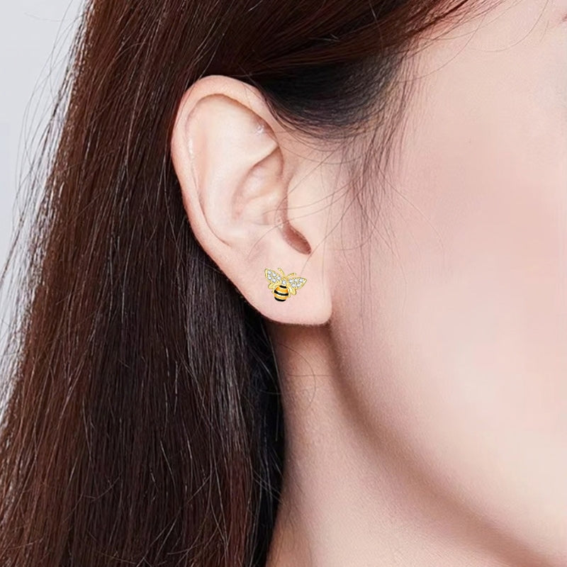 Goldfarbene Honigbienen Ohrstecker aus 925 Sterling Silber mit funkelnden Zirkonia Kristallen, schwarz-gelben Streifen und filigranen Flügeln.